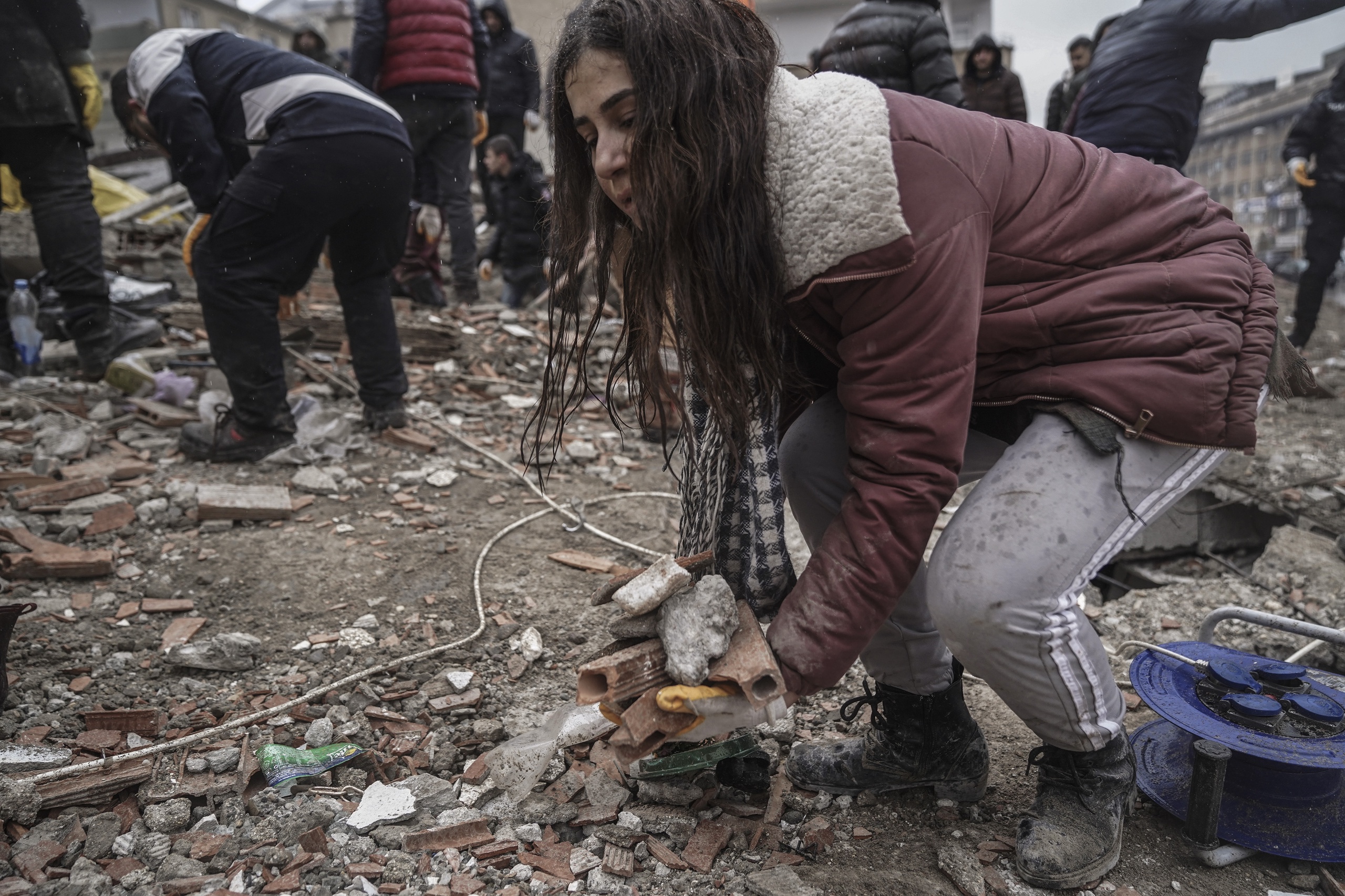 Een jonge vrouw ruimt puin in Gaziantep. Het Nederlandse zoek- en reddingsteam USAR is aangekomen in Turkije. Na de zware aardbeving heeft het land hulp gevraagd aan de hele wereld. En dus zijn er vanuit Nederland 65 mensen en ácht reddingshonden op pad om reddingswerk te verrichten.