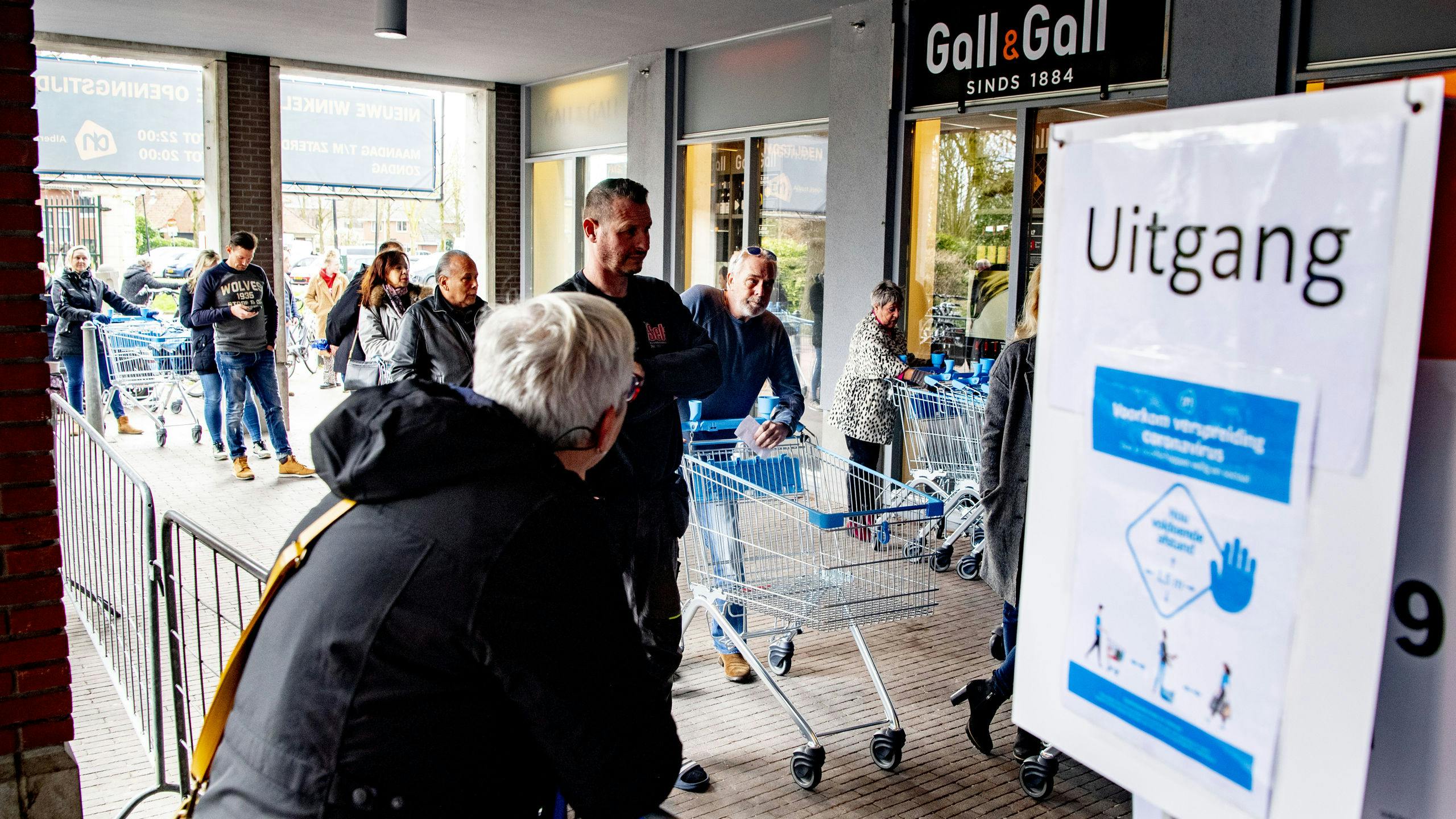 Medewerkers Albert Heijn werken achter plastic
