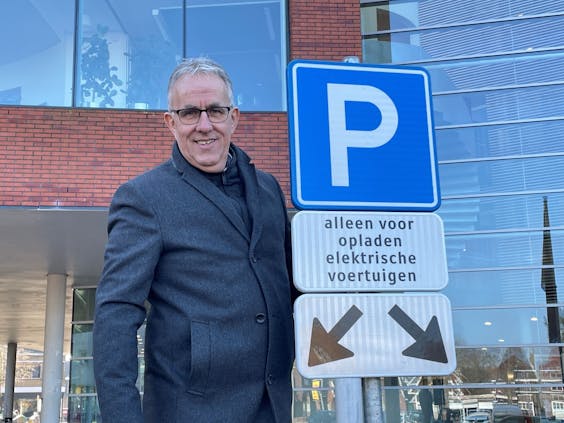 Wethouder Harry Scholten bij de oplaadplekken naast het gemeentehuis van Hof van Twente