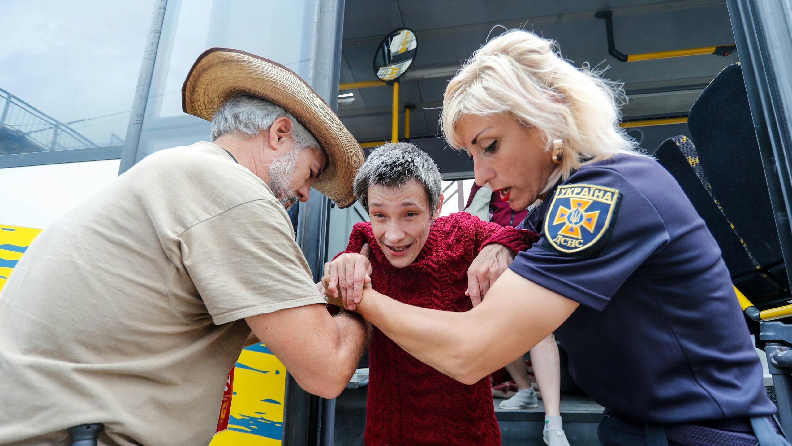 Vrijwilligers evacueren een invalide vrouw in Donetsk