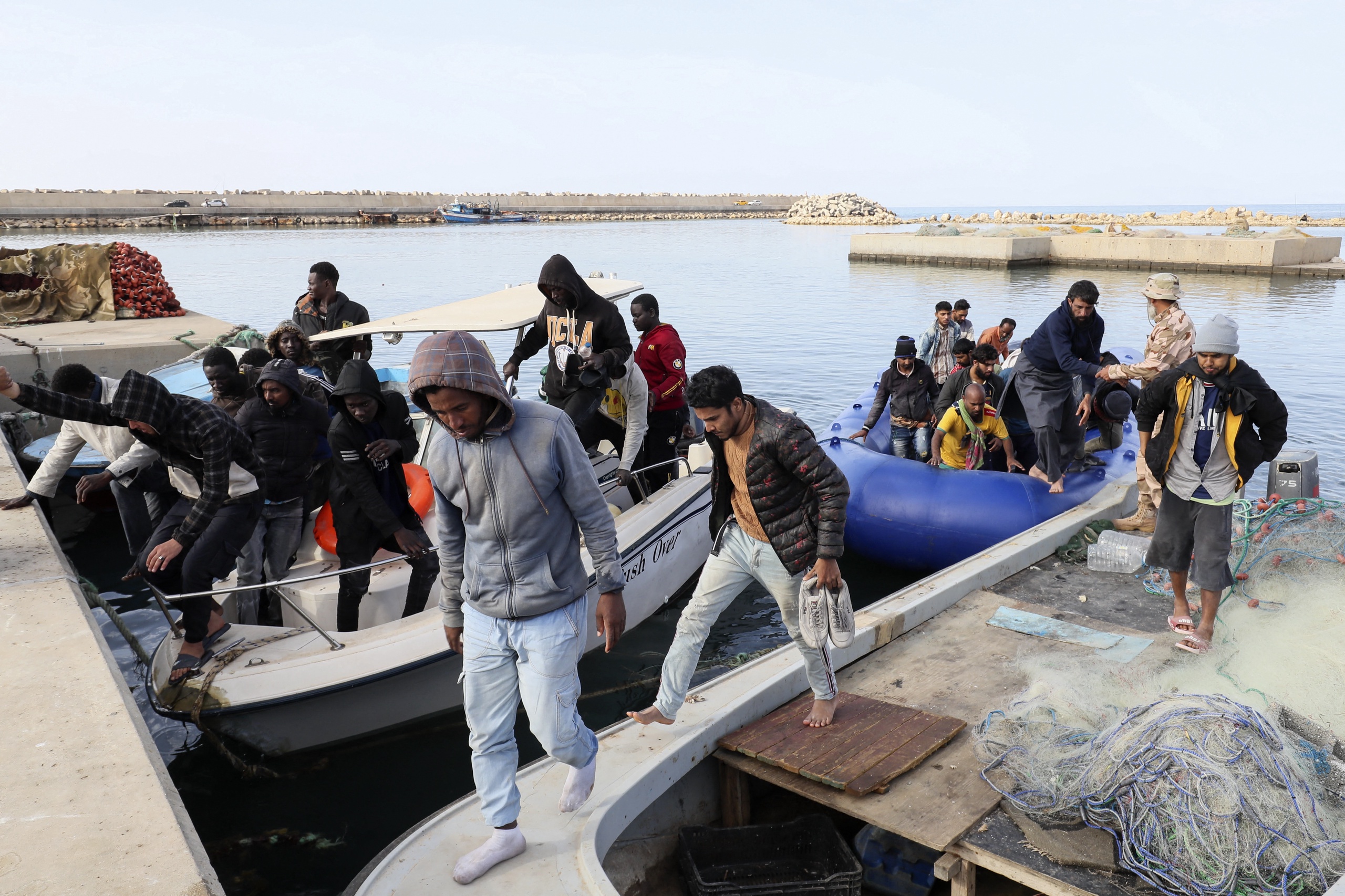 Migranten van verschillende nationaliteiten in een haven in het Garabulli-gebied, na hun redding op zee door de Libische kustwacht op 25 april 2023. 