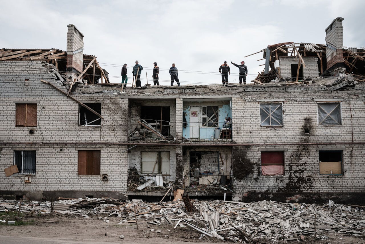 Werknemers ruimen puin op van een gebouw dat een maand geleden in Cherkaske is verwoest door beschietingen