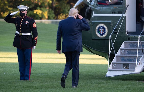 De Amerikaanse president Donald Trump voordat hij in de helikopter stapt onderweg naar het ziekenhuis.