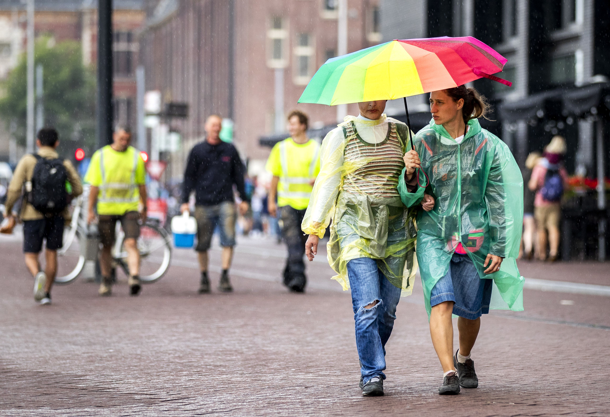 2018-08-09 15:31:47 AMSTERDAM - Toeristen en Amsterdammers in de regen. Na een lange periode van droog weer valt er op veel plaatsen veel regen. ANP REMKO DE WAAL