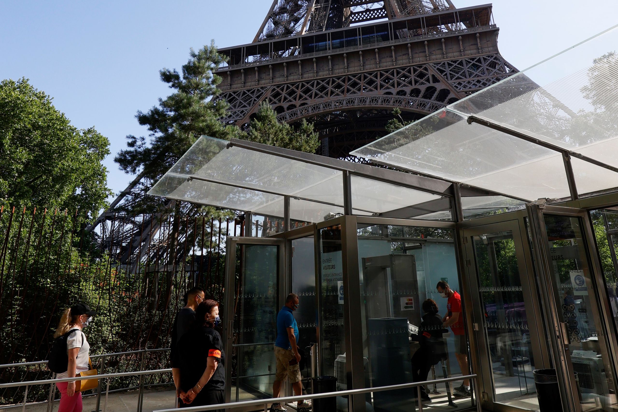 Bezoekers dragen mondkapjes bij de ingang van de Eiffeltoren 