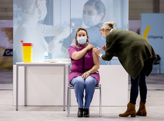 Sanna Elkadiri, medewerkster van verpleeghuis Het Wereldhuis, krijgt het eerste vaccin. Verleners van acute zorg, zoals ambulancepersoneel en IC-medewerkers worden in diverse ziekenhuizen geprikt tegen het coronavirus.