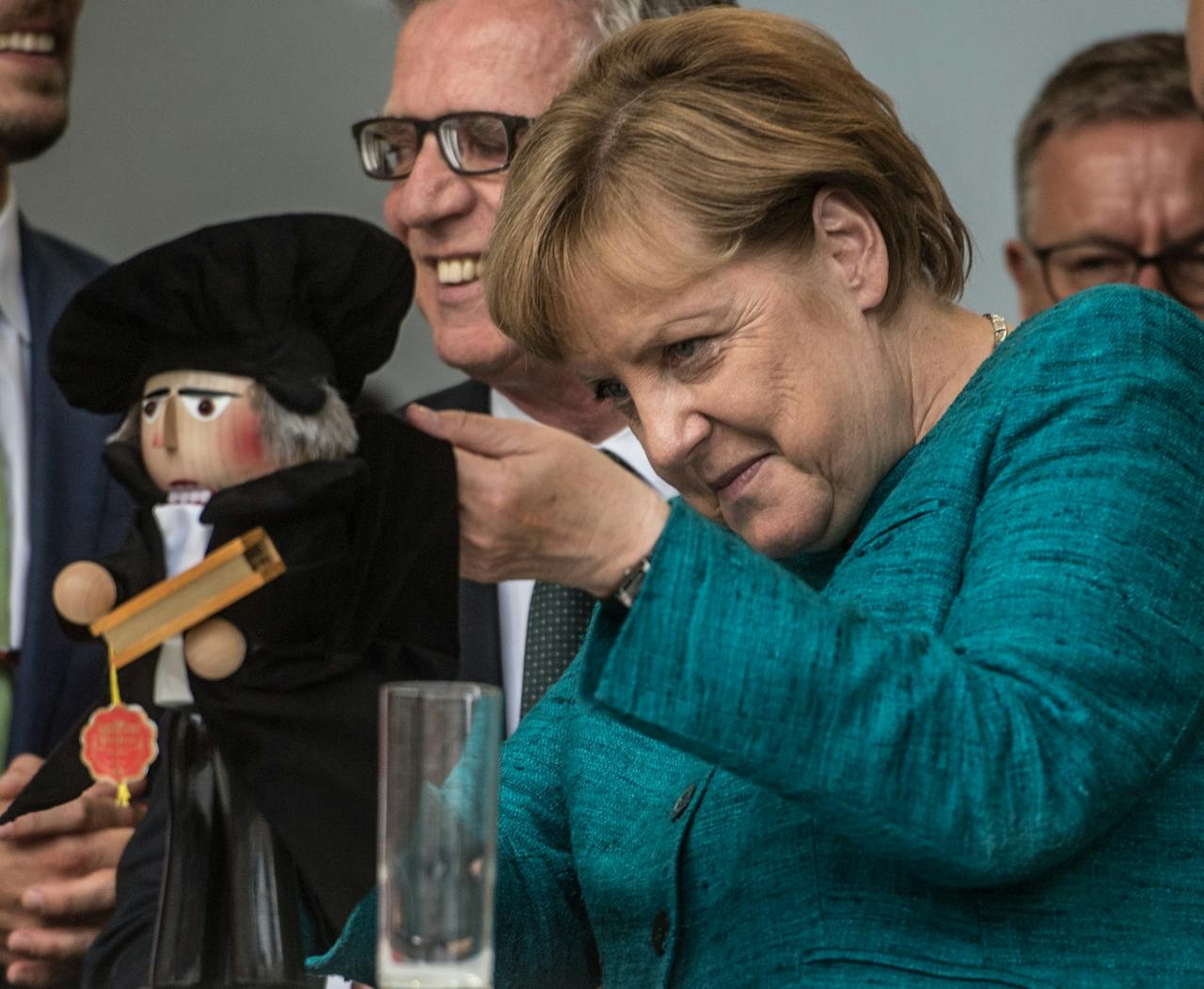 Het Lutherjubileum wordt in Duitsland groots gevierd. Bondskanselier Angela Merkel houdt een Luther-handpoppetje vast tijdens een campagnebijeenkomst van haar partij (CDU).