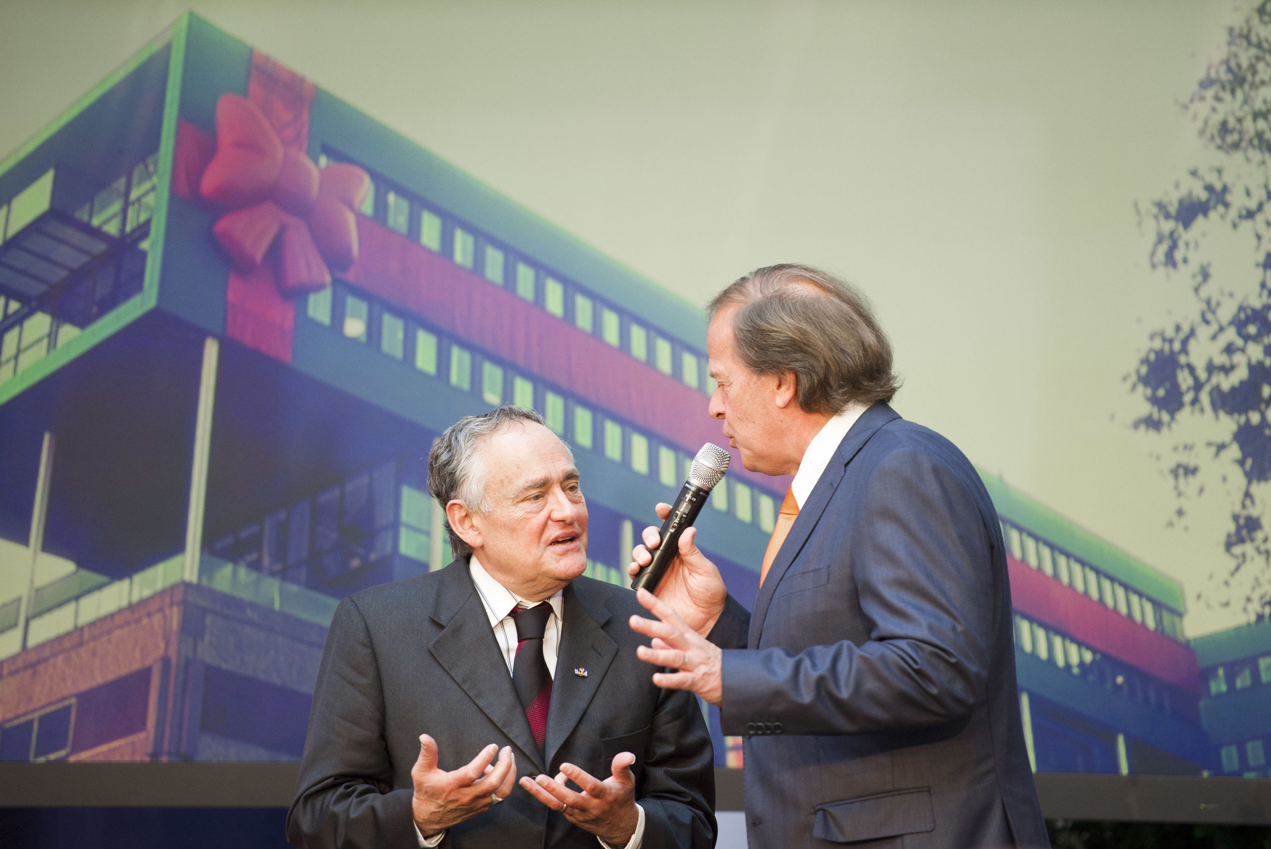 Prof. dr. Bob Pinedo (oprichter VUmc CCA, links), ondervraagd door Ivo Niehe kort voor de openingshandeling van het nieuw instituut (projectie op de achtergrond).