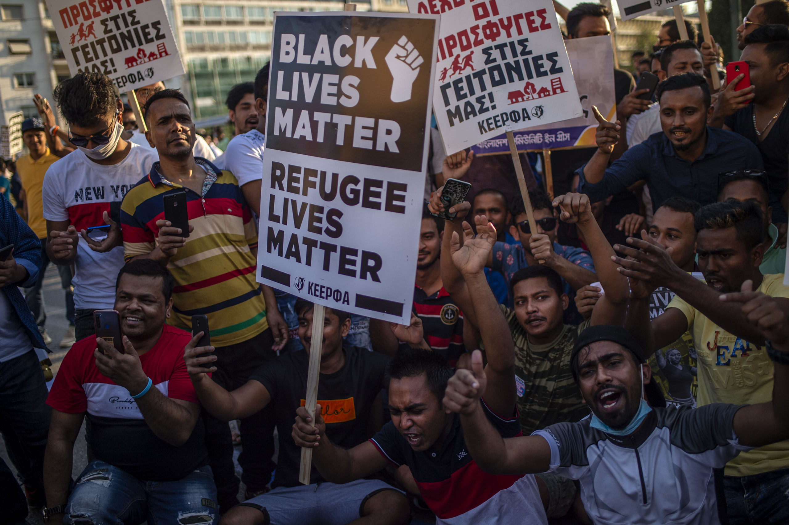 2020-06-26 20:40:29 A protester holds a placard reading "Black Lives Matter, Refugee Lives Matter" during a demonstration to demand rights and housing for refugees and migrants in Greece, on June 26, 2020. ANGELOS TZORTZINIS / AFP