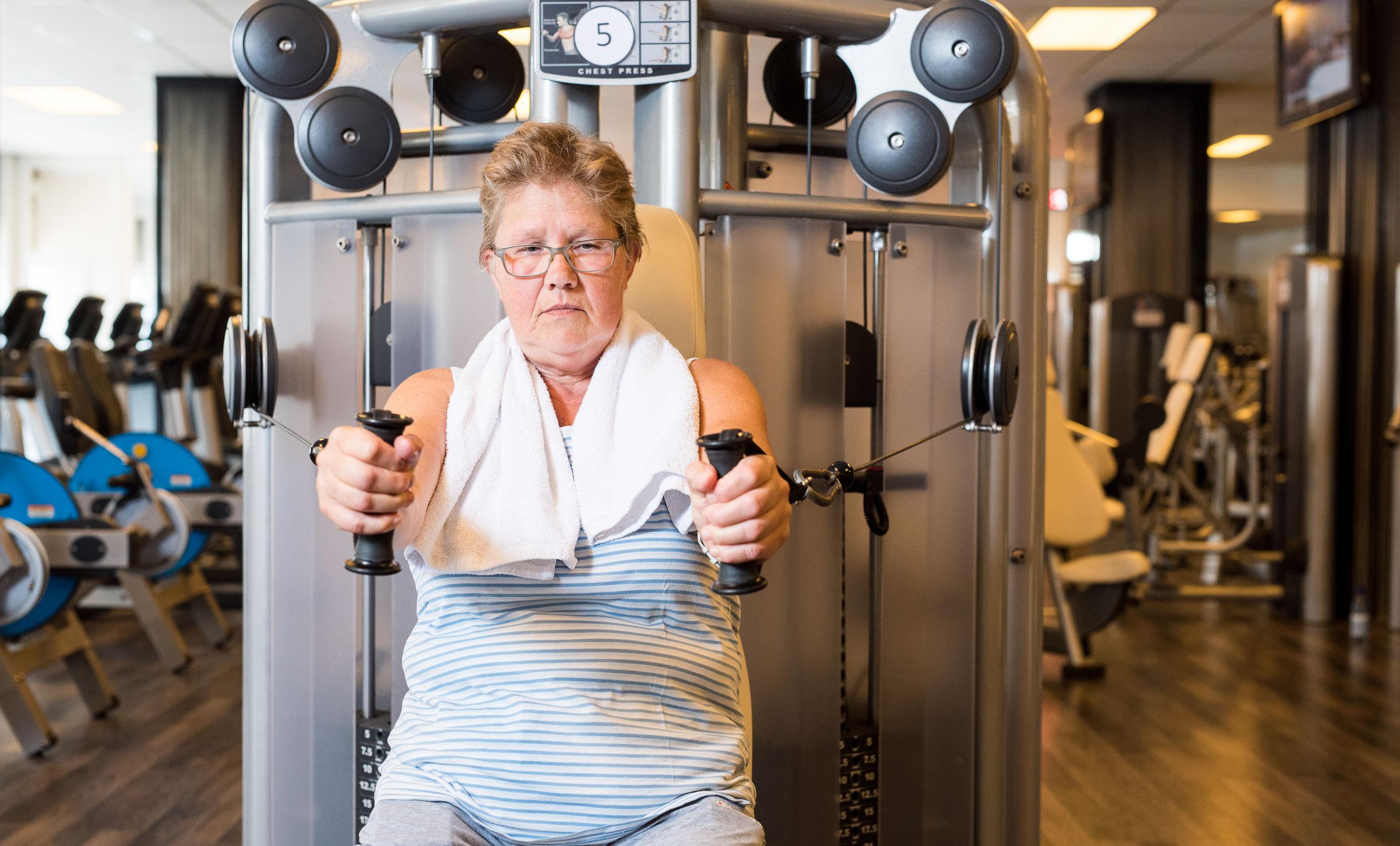 Een senior traint tijdens de fitnessles voor 50plussers